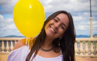 chica sonriendo con un globo amarillo