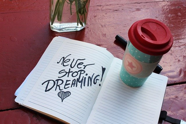 café junto a un cuaderno donde se lee nunca dejes de soñar