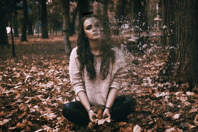 mujer triste en un bosque en otoño