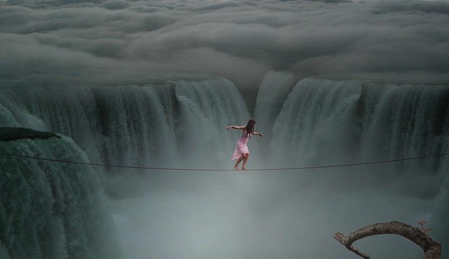 mujer atravesando unas cataratas haciendo equilibrio sobre una cuerda