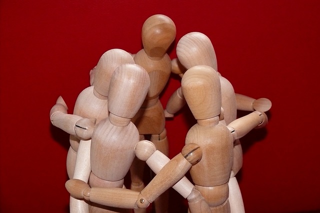muñecos de madera representando un grupo de personas que se abrazan