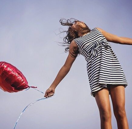 mujer respirando feliz con un globo en la mano