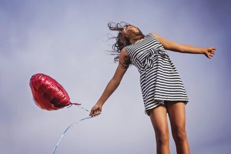 mujer respirando feliz con un globo en la mano